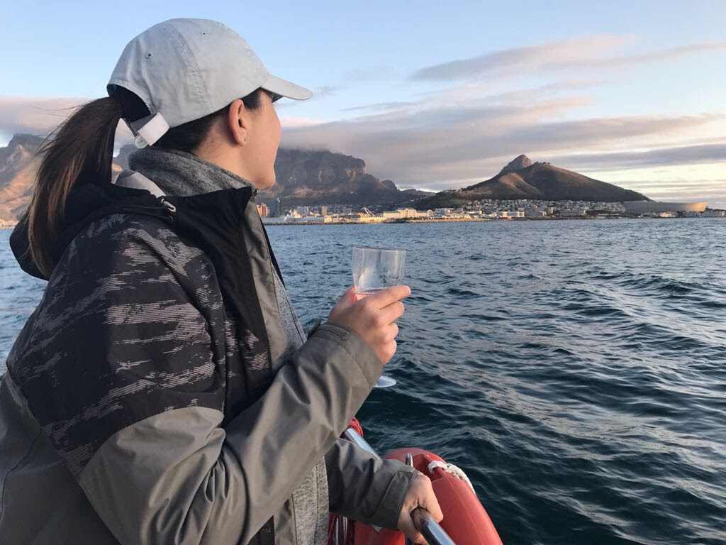 Girl drinking champagne on a boat looking out to Lions Head and Table Mountain South Africa