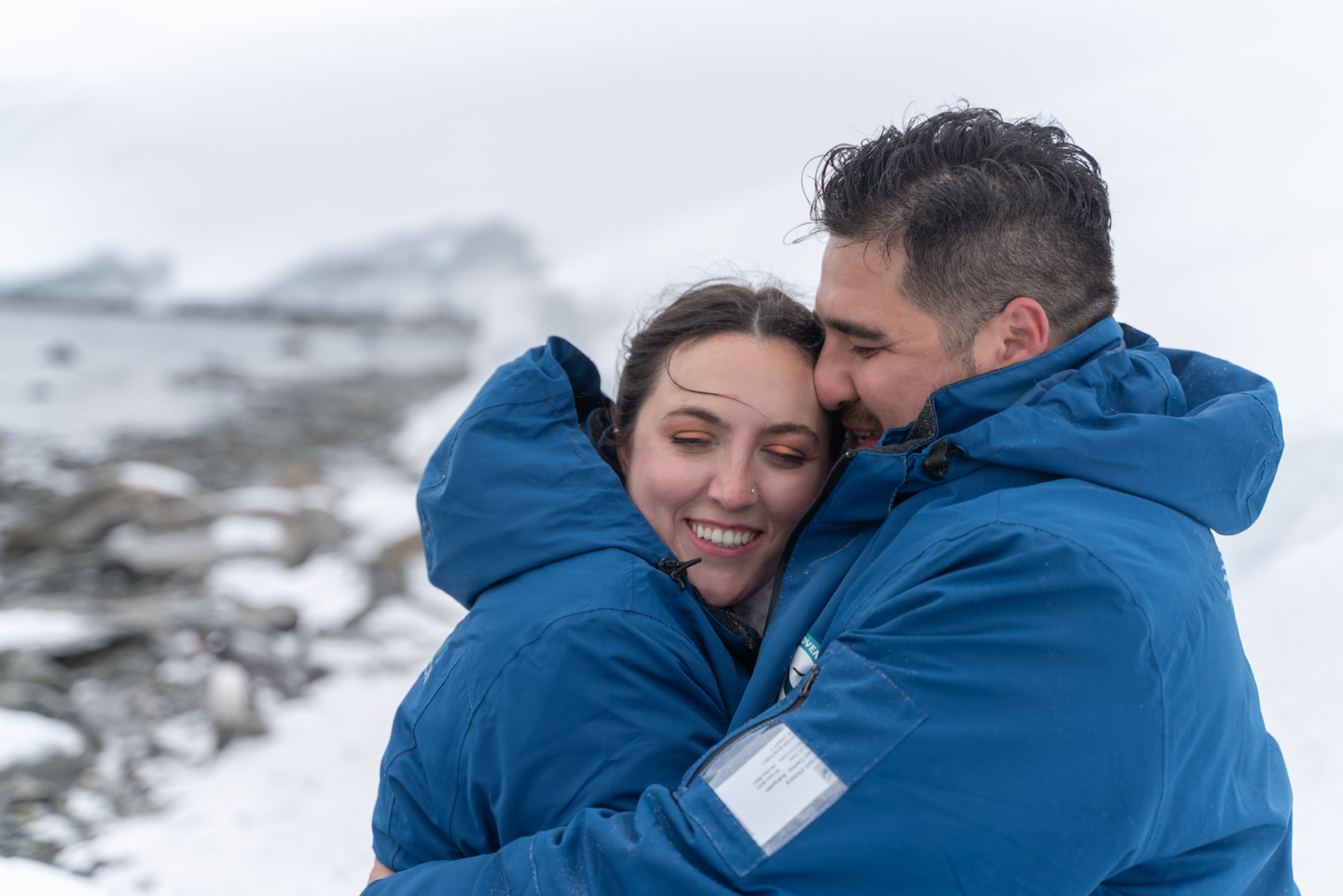 couple hugging lovingly in Antarctica elopement surrounded by snow